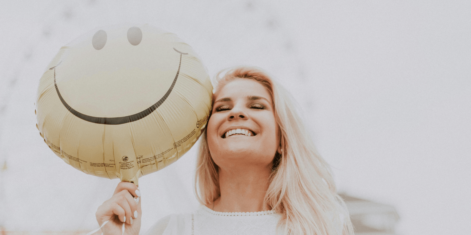 A Happy Woman With A Smiley Balloon