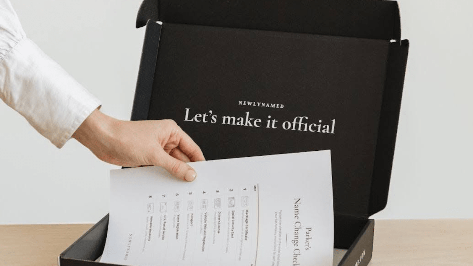 A Person Putting Papers In A NewlyNamed Box