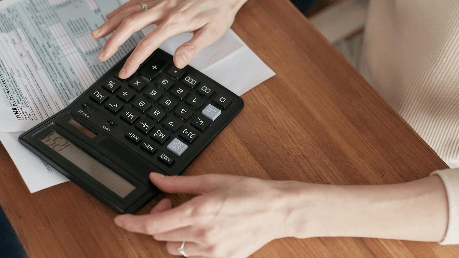 A Woman Using A Calculator For Her Tax Forms