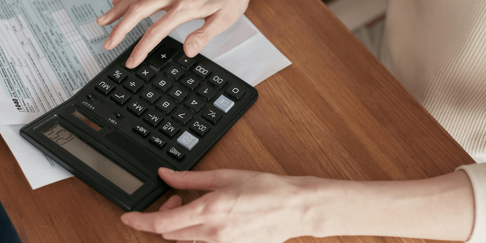 A Woman Using A Calculator For Her Tax Forms