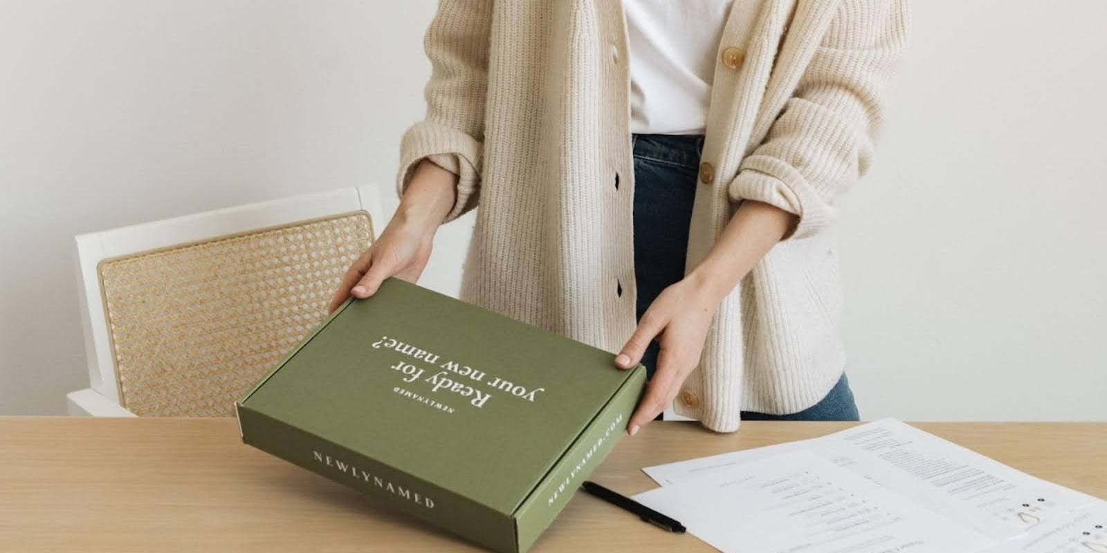 A woman opening a newlynamed box