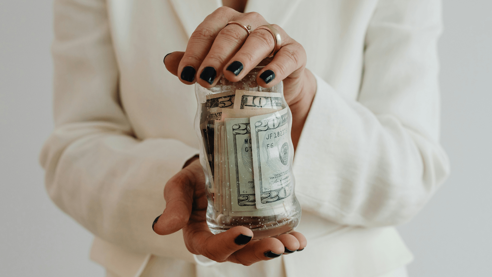 Woman Holding Jar Of Money For Her Wedding Budget