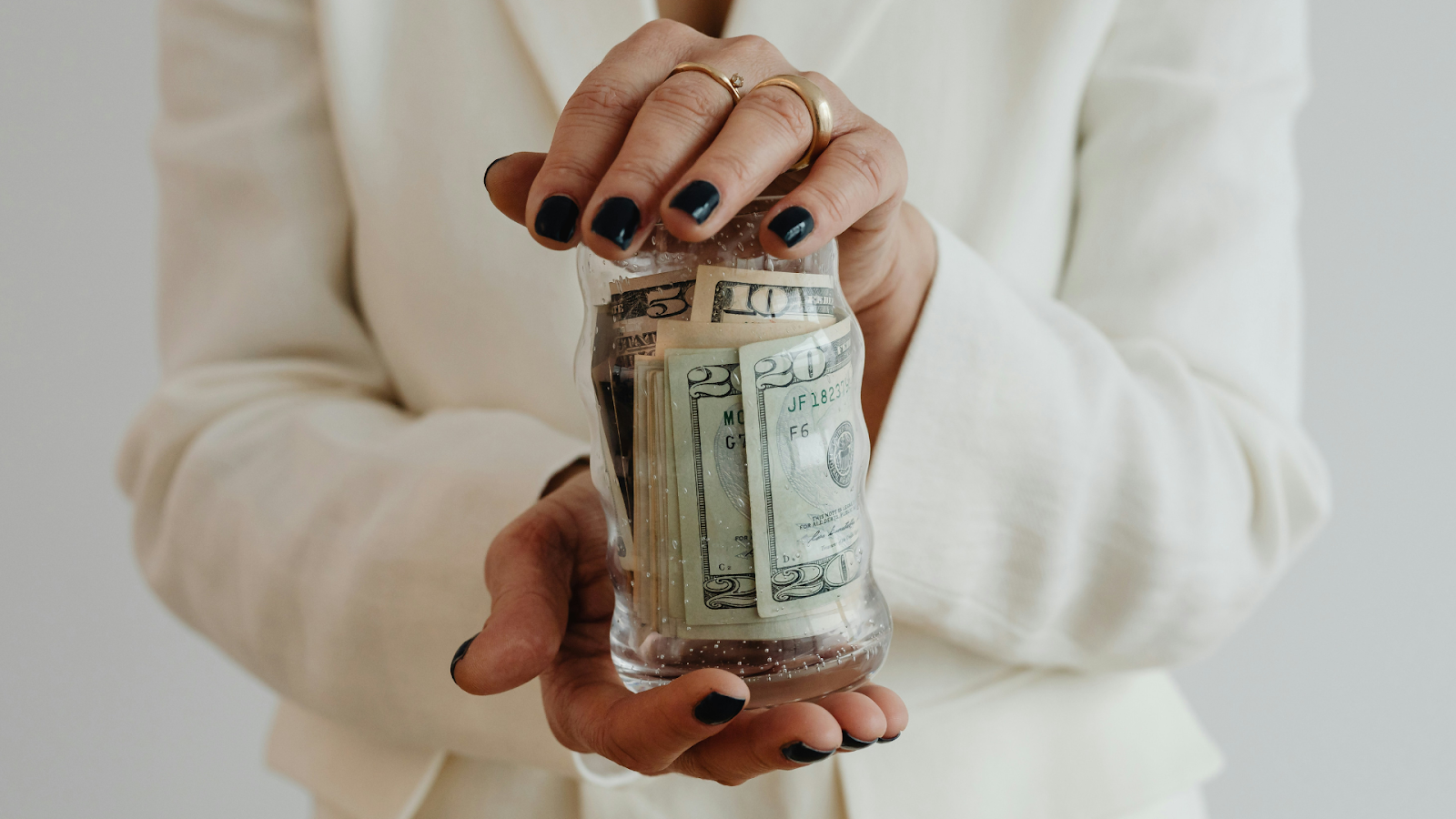 Woman Holding Jar Of Money For Her Wedding Budget