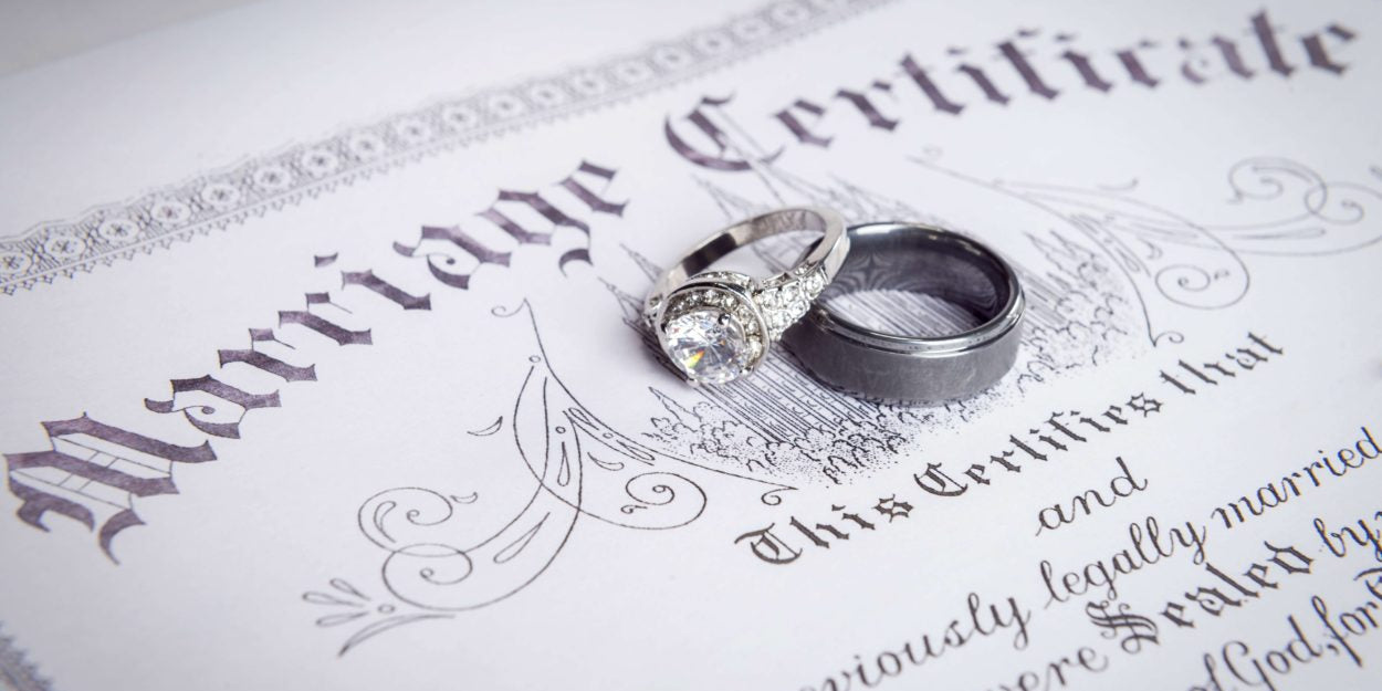 marriage certificate with bride and groom rings