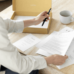 Woman holding pen with newlynamed name change kit and forms