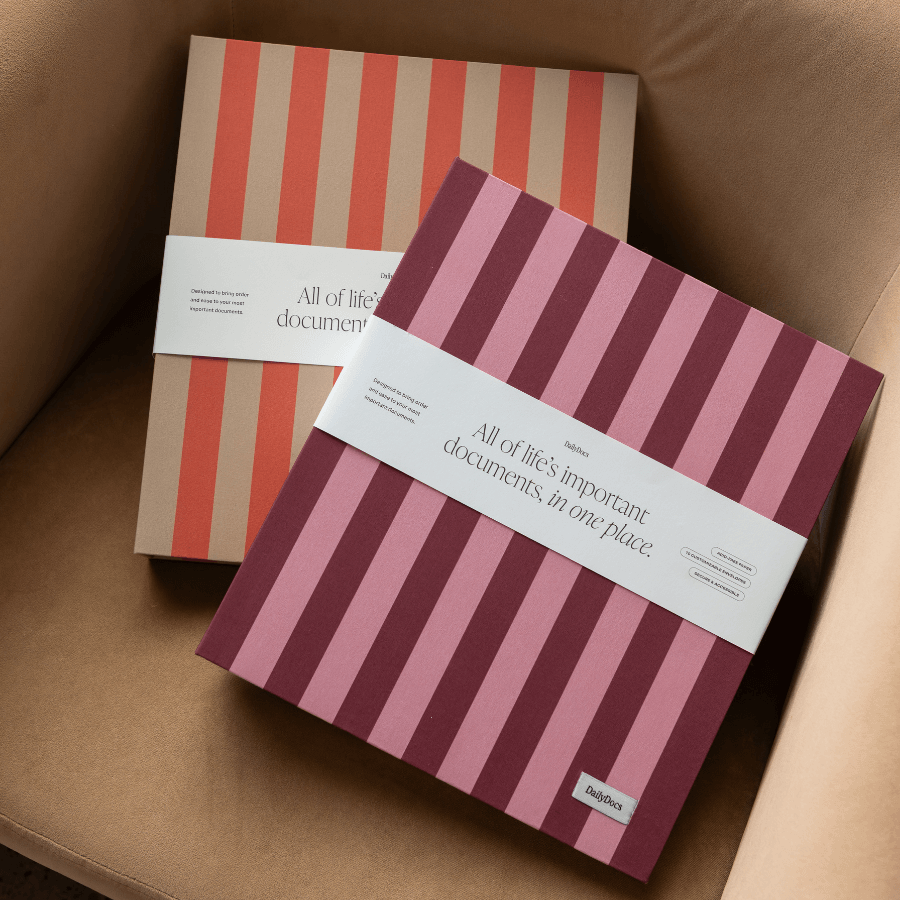Two DailyDocs organizers with striped covers and labels on a brown surface