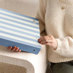 DailyDocs document organizer in Cloud blue and white striped design held in a lifestyle setting