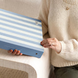 DailyDocs document organizer in Cloud blue and white striped design held in a lifestyle setting