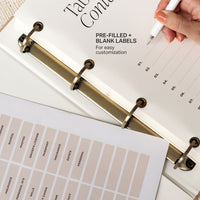 Table of contents with pre-filled and blank labels for customization, held by a hand with a pen.