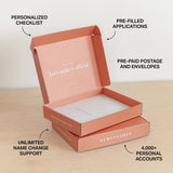 Open pink NewlyNamed Box with text highlighting features on a light wooden surface.