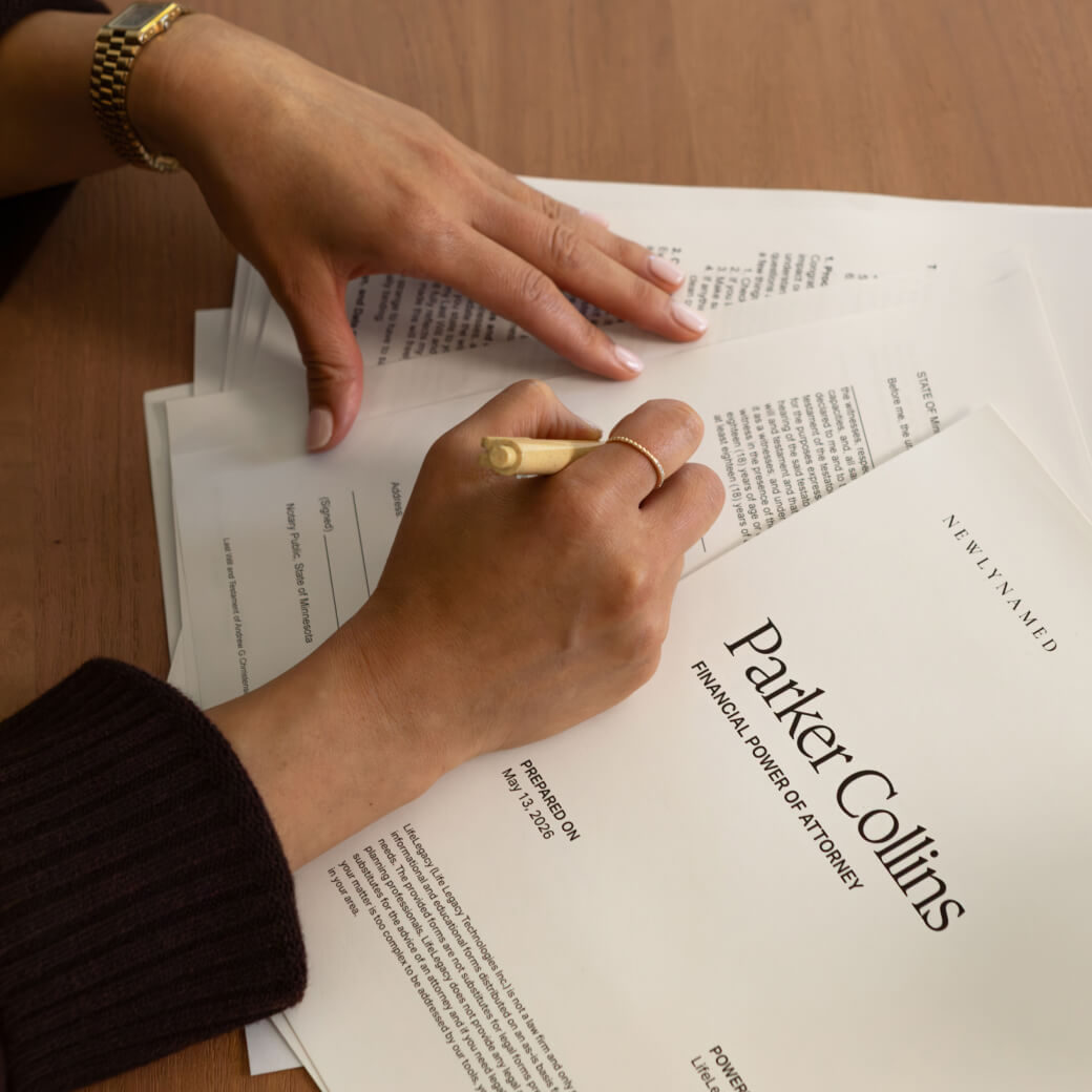 A close-up view of a person's hands filling out a legal document titled 