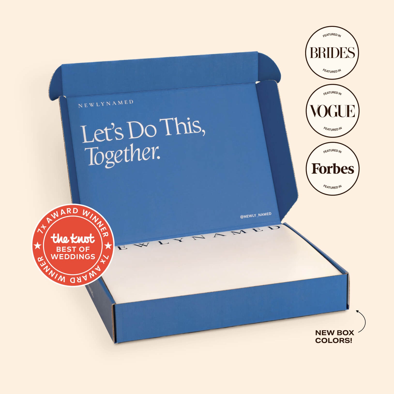 An open blue NewlyNamed Box complete marriage name change kit featuring award badges from The Knot, Brides, Vogue, and Forbes.