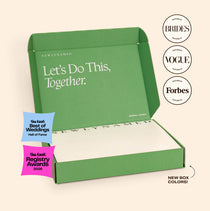 An open green NewlyNamed Box marriage name change kit showcasing features in Brides, Vogue, and Forbes magazines.