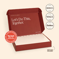 An open deep red NewlyNamed Box premium name change service kit with the inner lid reading Let's Do This, Together.